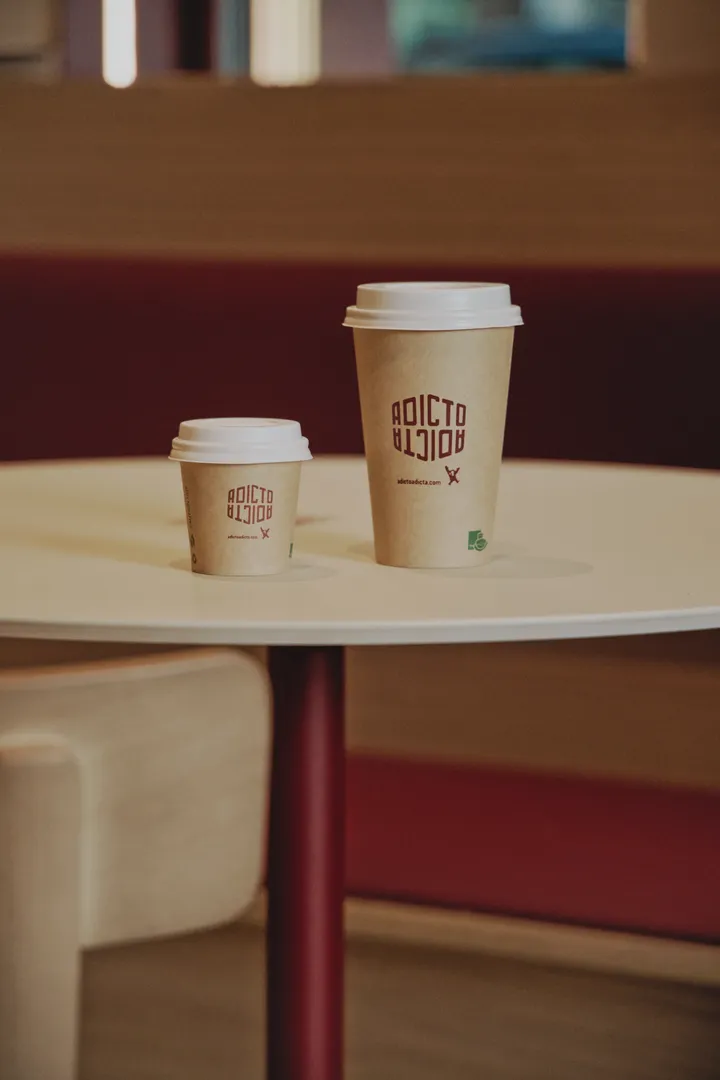 Dois copos de café para levar sobre uma mesa