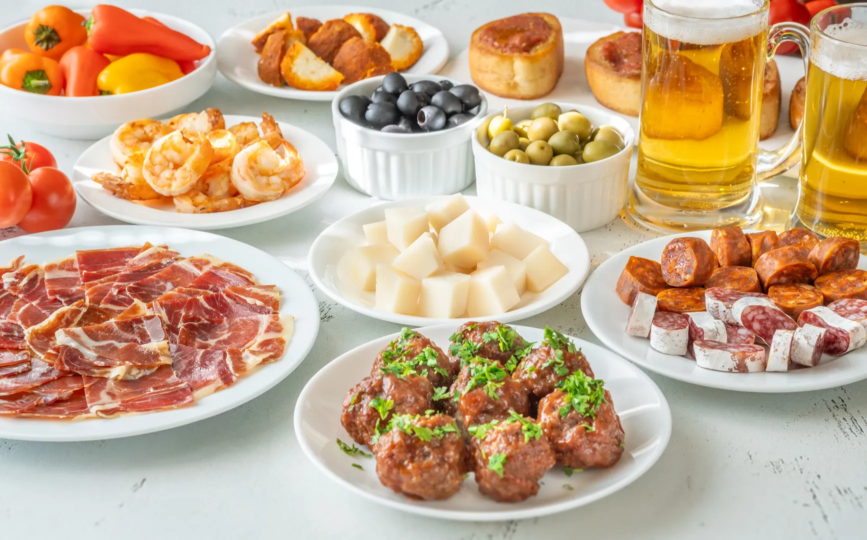 Petiscos variados, pão e bebidas dispostos numa mesa