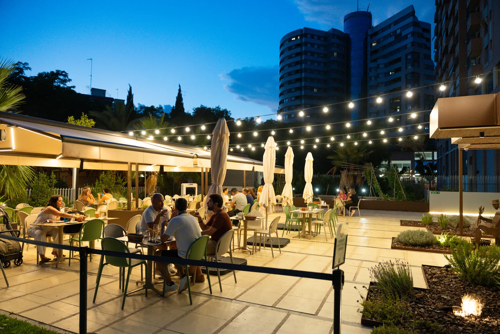 Esplanada iluminada em Valência ao anoitecer, ideal para jantar em setembro