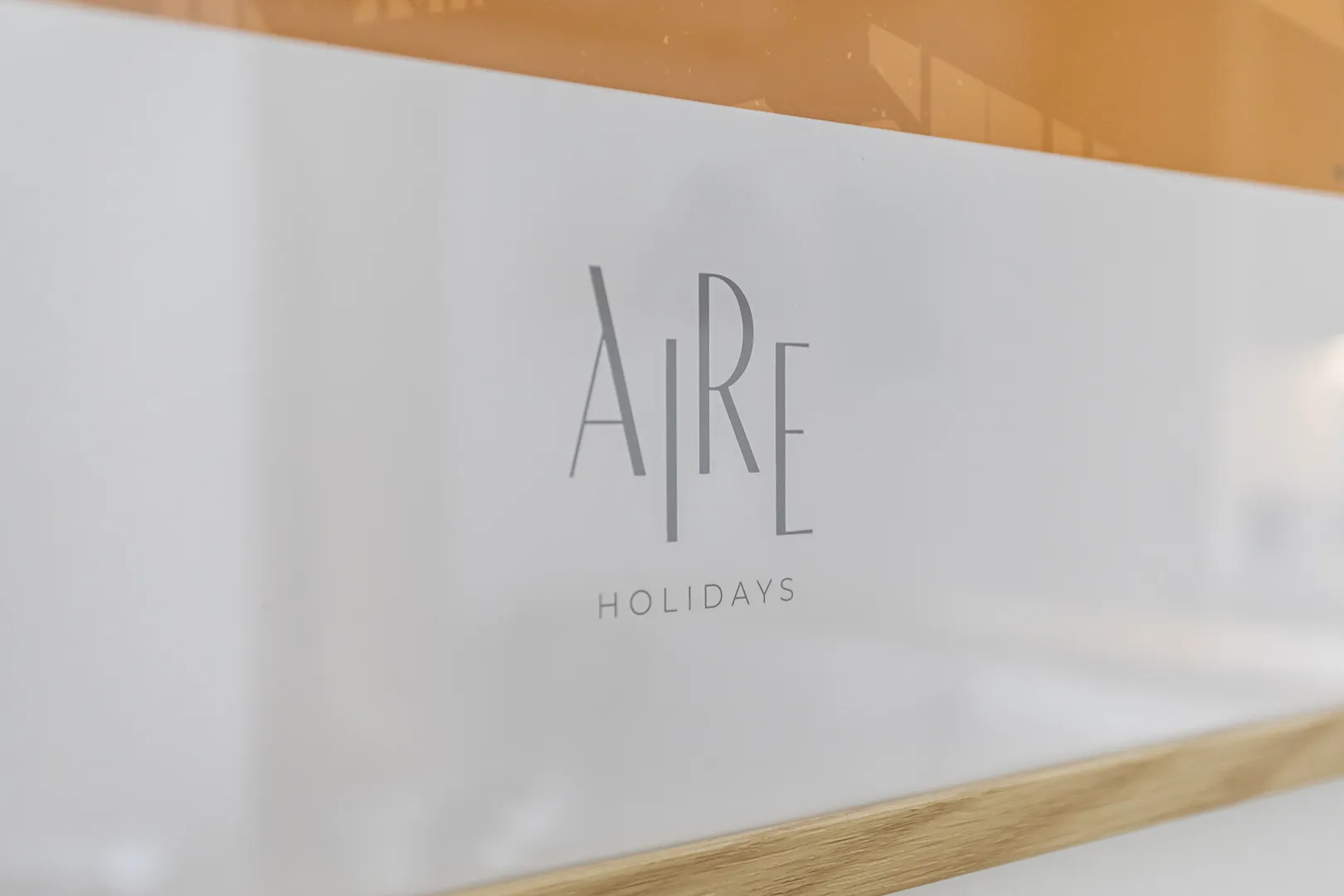 Logótipo Aire Holidays numa superfície translúcida