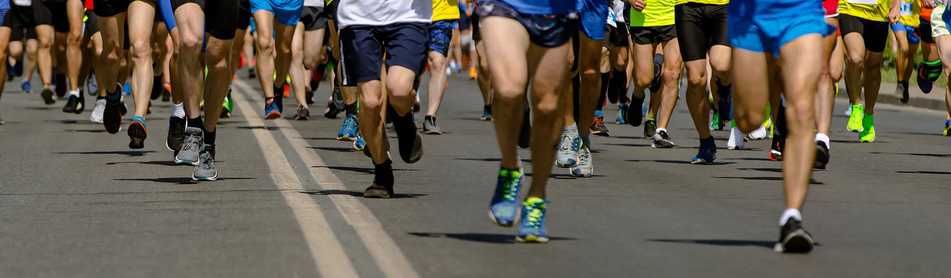 Corredores em prova urbana numa avenida durante uma corrida