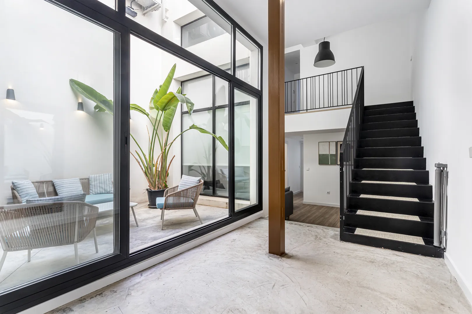 Pátio interior envidraçado junto de uma escada de um duplex