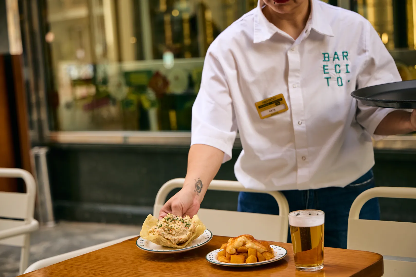 Empregado a servir pratos numa mesa de restaurante