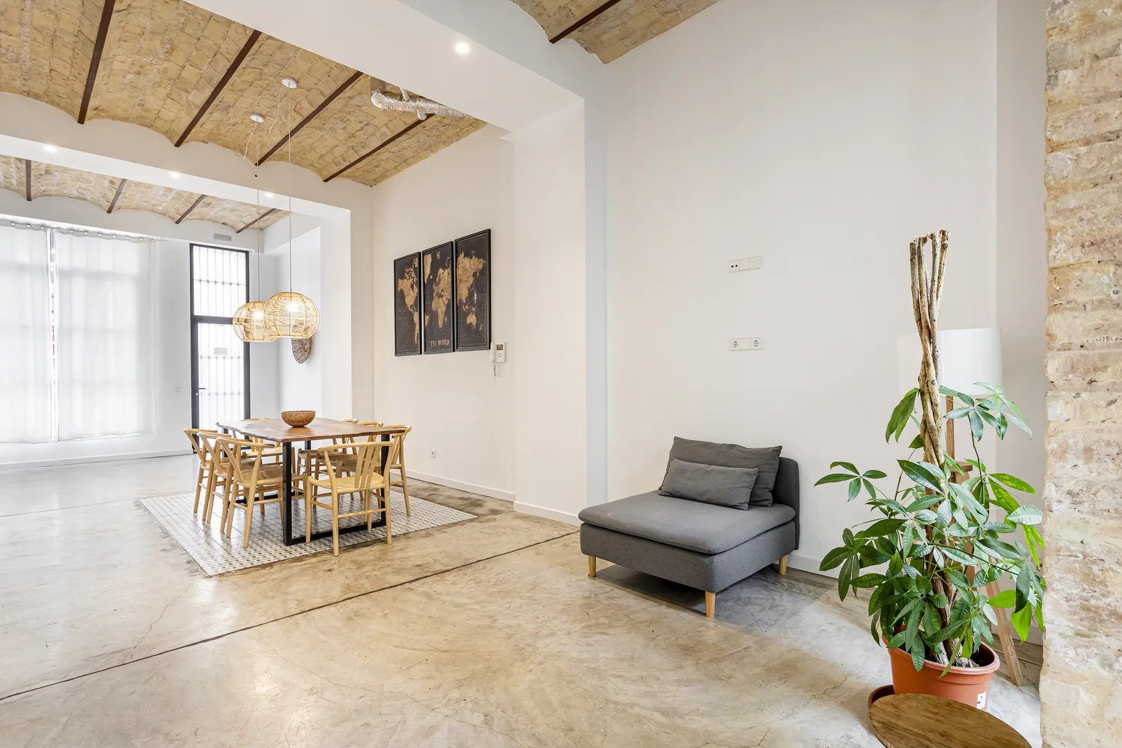 Sala com vigas de madeira, mesa de refeições e um cadeirão